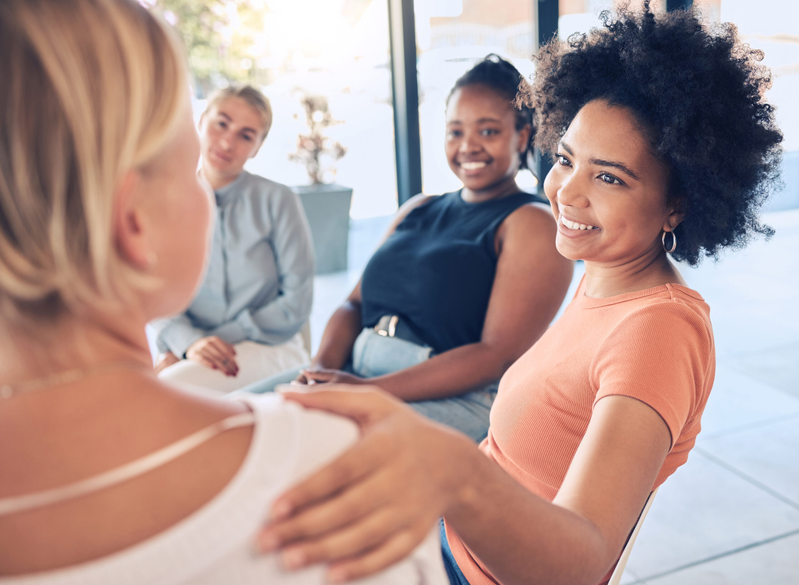 Diverse group of women sitting together in a calm, supportive setting