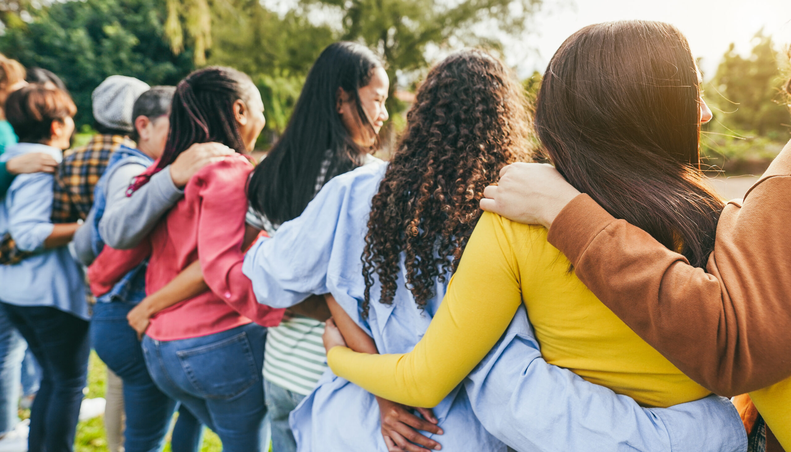 Women gathered in a warm, supportive group setting — natural connection and community