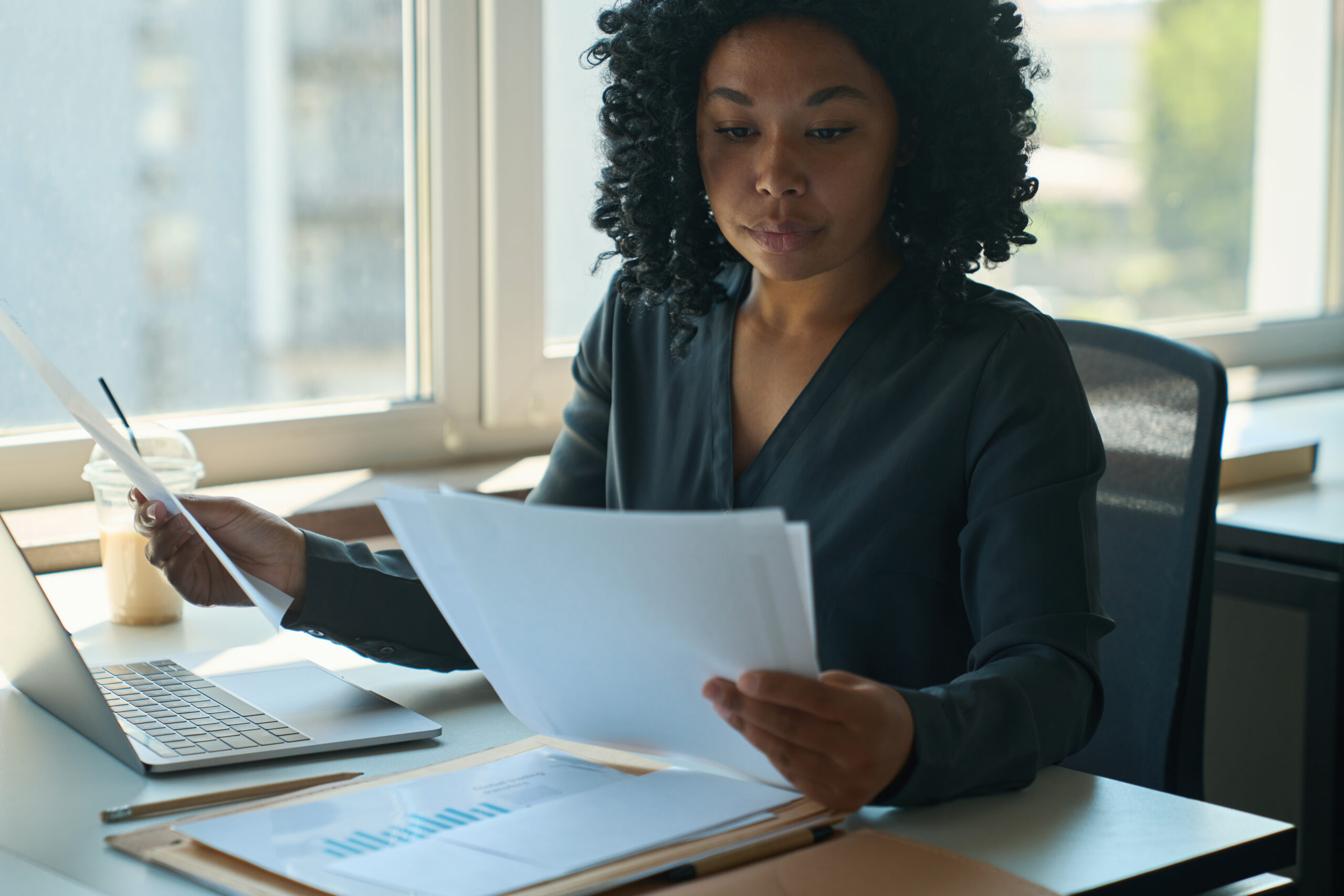 Woman sitting confidently reviewing documents — calm, focused, and prepared