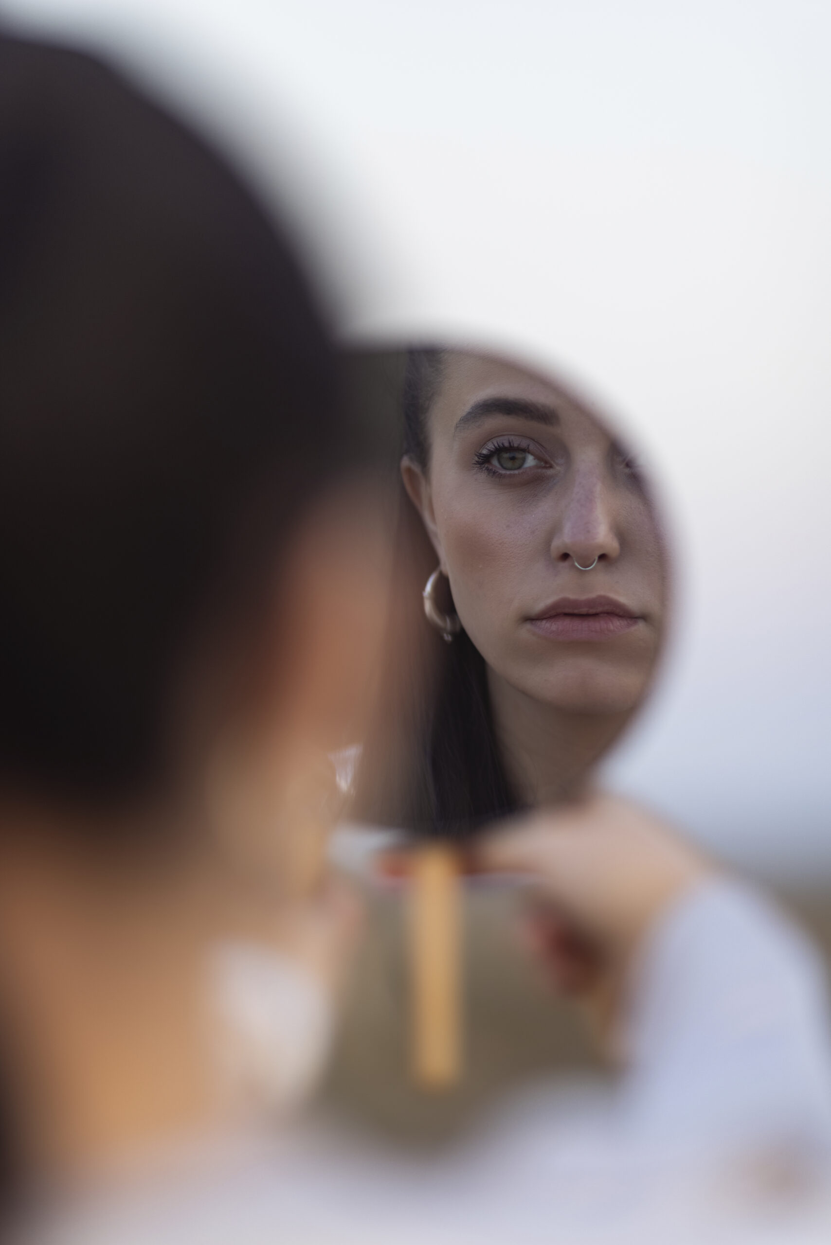 Woman sitting alone in soft, reflective light — thoughtful and quiet
