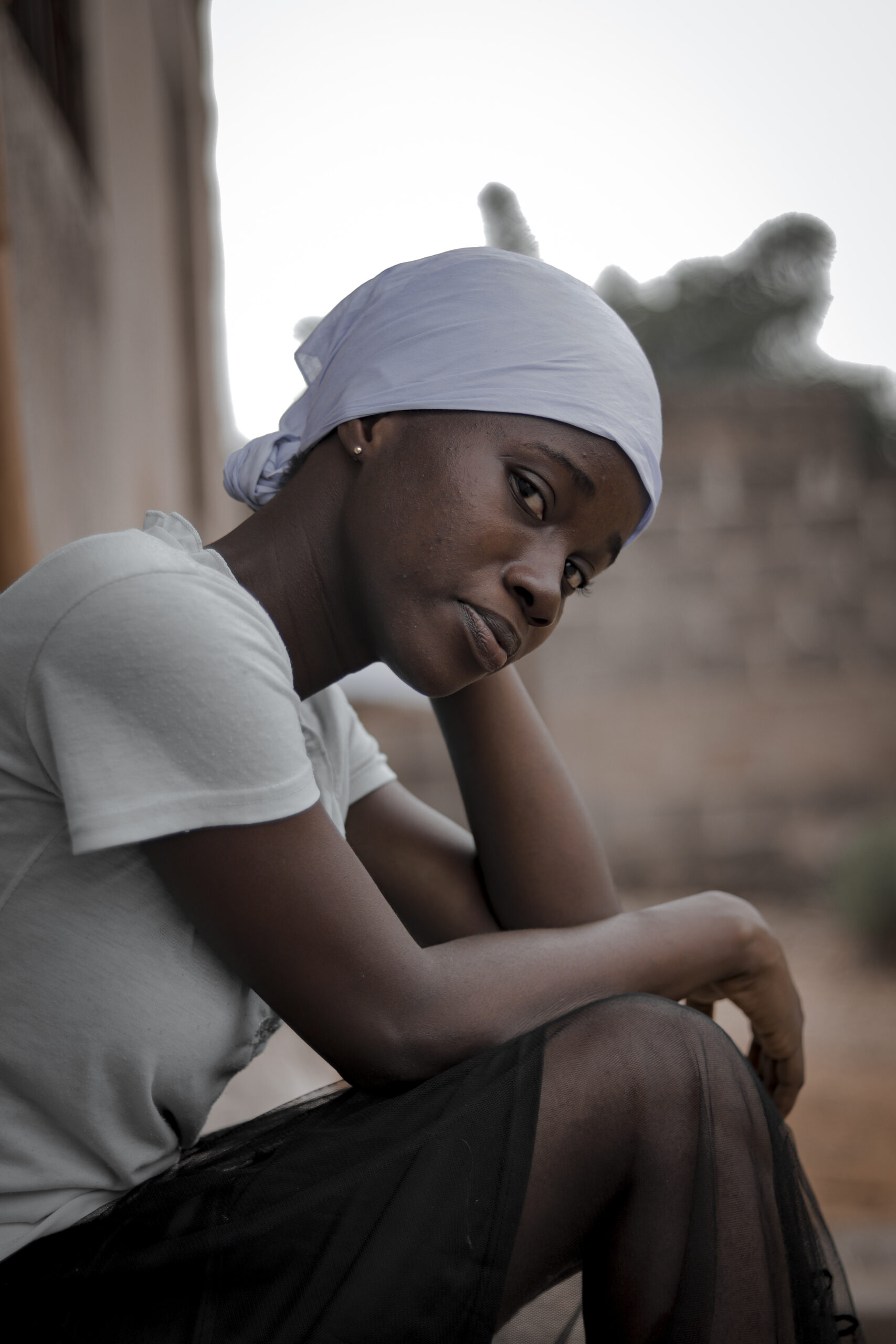 Woman in a quiet, reflective moment — soft expression, understated struggle