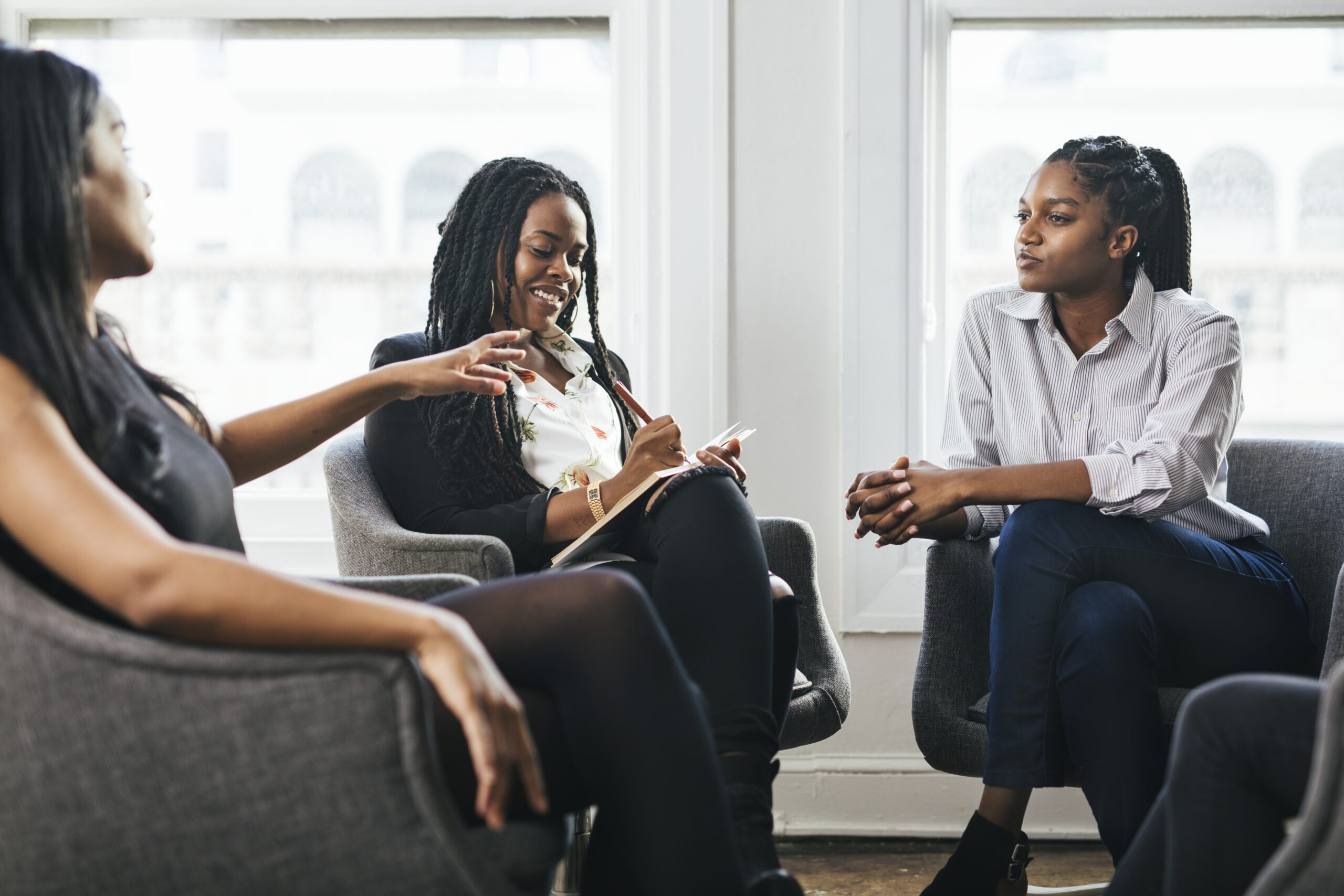 Diverse women in a group setting — engaged in supportive discussion