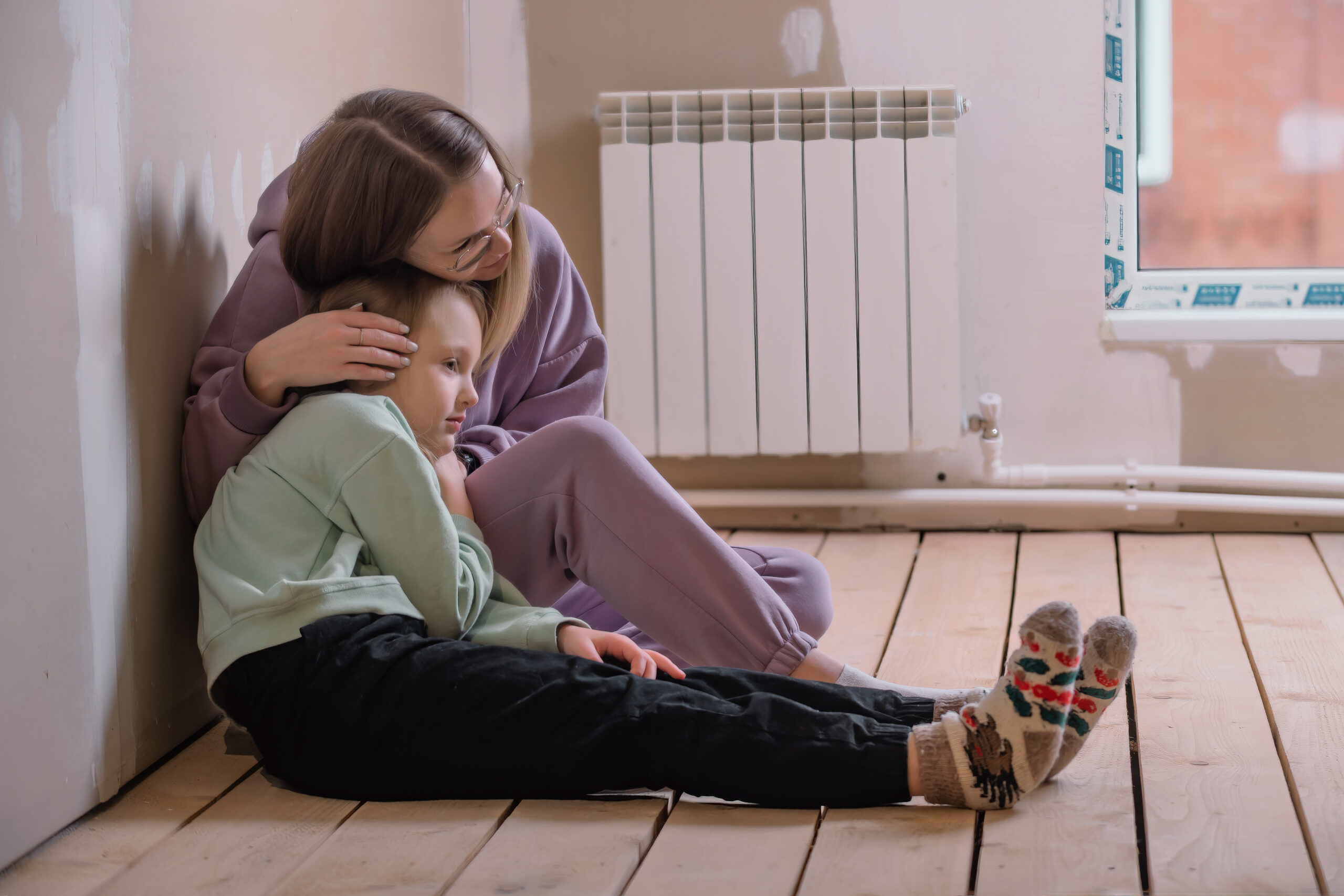 Mother and child in a quiet, modest home — thoughtful and hopeful atmosphere