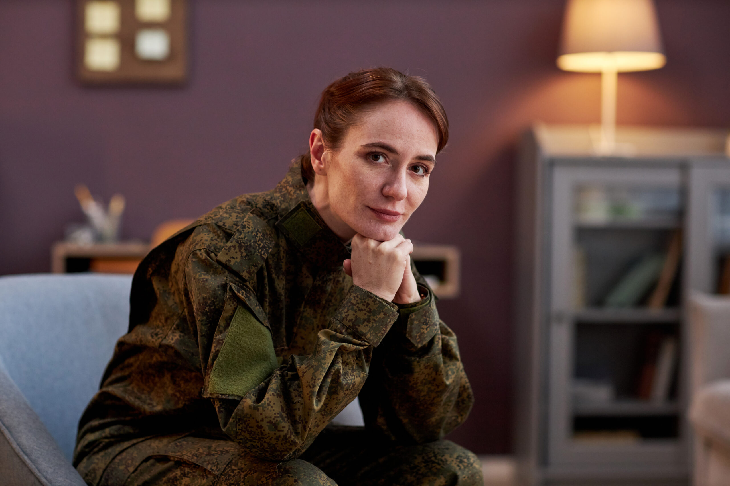 Veteran sitting in a chair, in a calm setting, reflecting with quiet dignity
